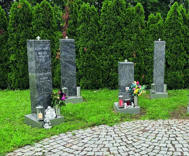 Unterschiedliche Säulenhöhen vor einer Hecke